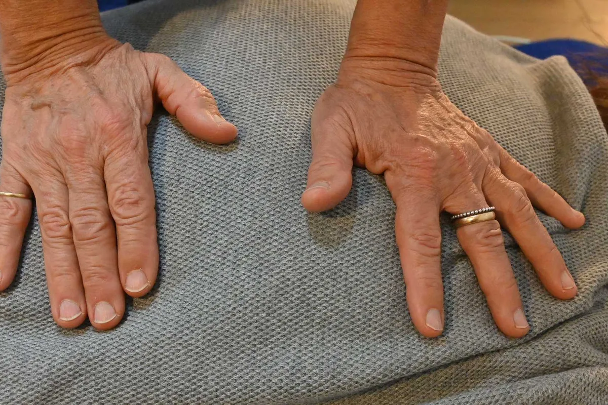 Le mani di Oriana Viozzi appoggiate sulla schiena durante un trattamento Shiatsu, con pressioni portate lungo il corpo