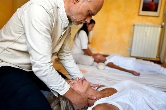 Operatrice Shiatsu durante un trattamento olistico, con pressioni portate lungo il corpo